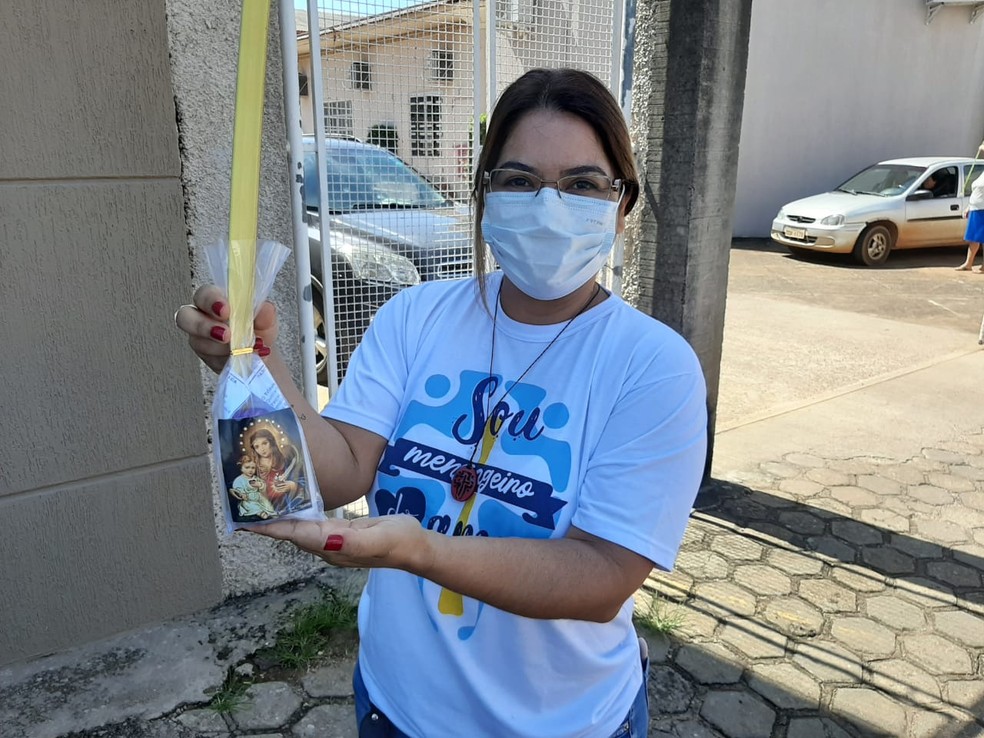 Voluntária entregou kits aos fiéis que passaram de carro na rua da paróquia, em Porto Velho — Foto: Diêgo Holanda/G1