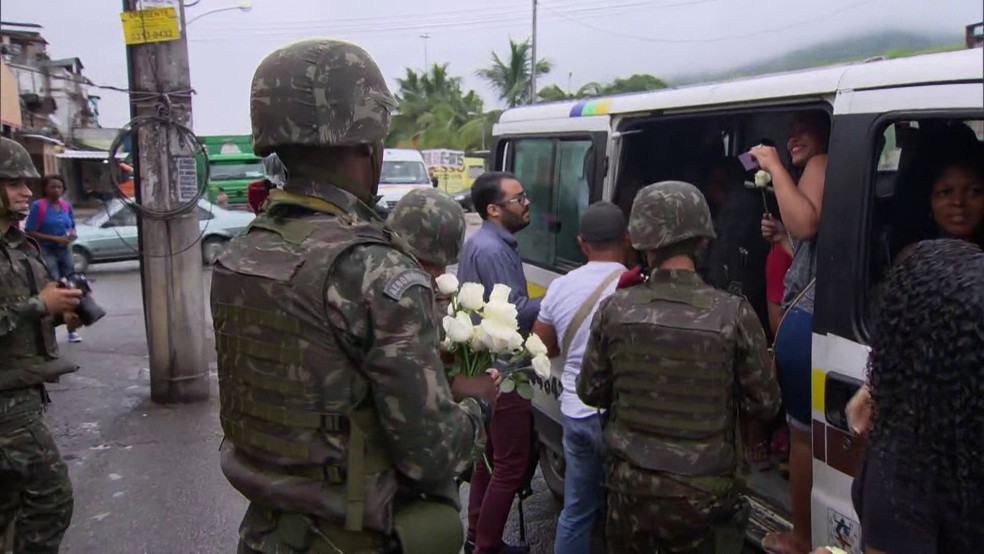 Homens do Exército distribuem rosas para moradoras da Vila Kennedy (Foto: Reprodução / TV Globo)