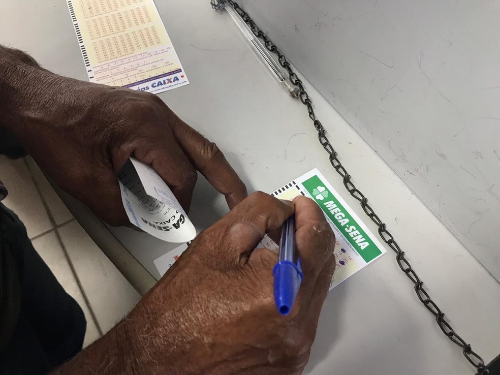Homem preenche cartão de aposta para a Mega Sena acumulada em R$ 170 milhões — Foto: Larissa Cunha/ G1