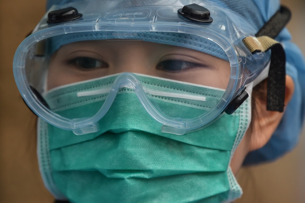 Agente de saúde usando equipamento protetor contra o Covid-19 trabalha em um hospital de Xangai, na China, nesta segunda (9). — Foto: Hector Retamal / AFP