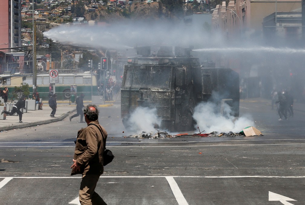 Forças de segurança atiram jatos d'água em manifestante durante tumulto em protesto em Valparaíso, no Chile — Foto: Rodrigo Garrido/Reuters