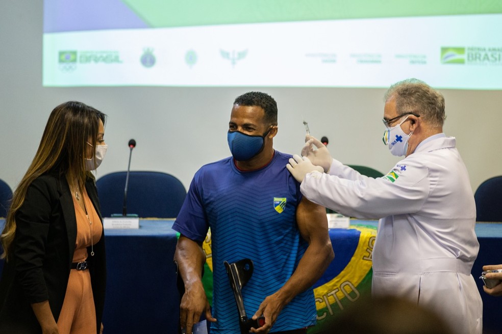 O remador paralímpico Michel Pessanha é vacinado pelo ministro da Saúde, Marcelo Queiroga — Foto:  Miriam Jeske/COB