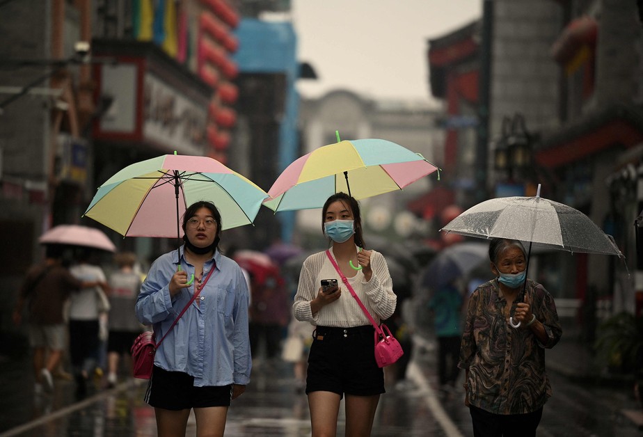 Pedestres caminham em rua de Pequim