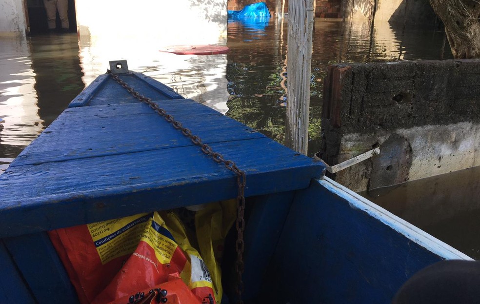 Com casas ilhadas, moradores se locomovem em canoas — Foto: Pedro Trindade/Inter TV Cabugi