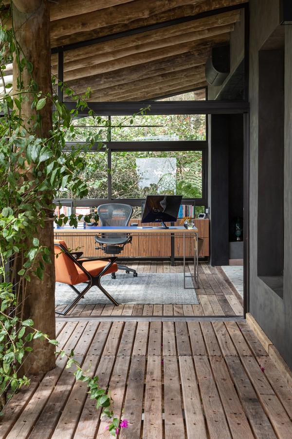 Cabana de 100 m² exibe sala com lareira e home office na varanda (Foto: Evelyn Müller)