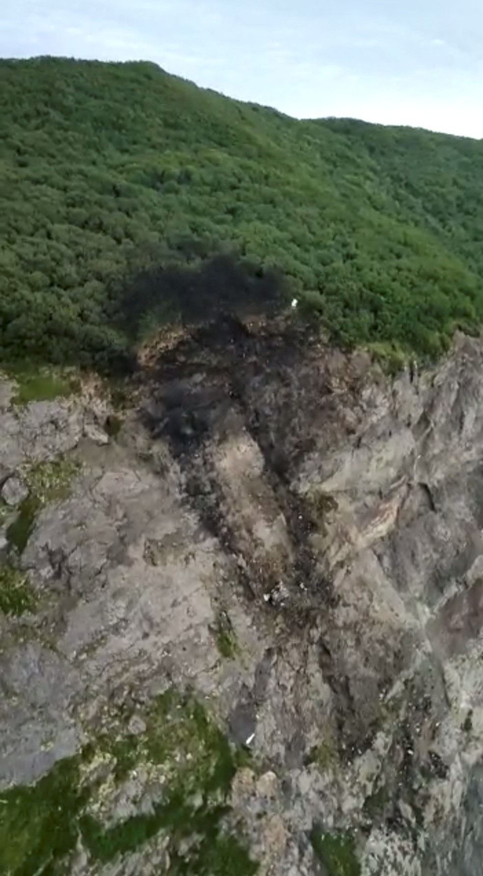 Imagem mostra o local onde o avião An-26 se chocou e caiu perto do aeroporto de Palana, no norte da península de Kamchatka, em 6 de julho de 2021 na Rússia — Foto: Ministério de Emergências da Rússia via Reuters