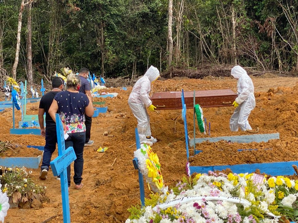 Coveiros do cemitério Nossa Senhora de Aparecida, em Manaus, enterram corpo de morto por Covid-19. — Foto: Carolina Diniz/G1 AM