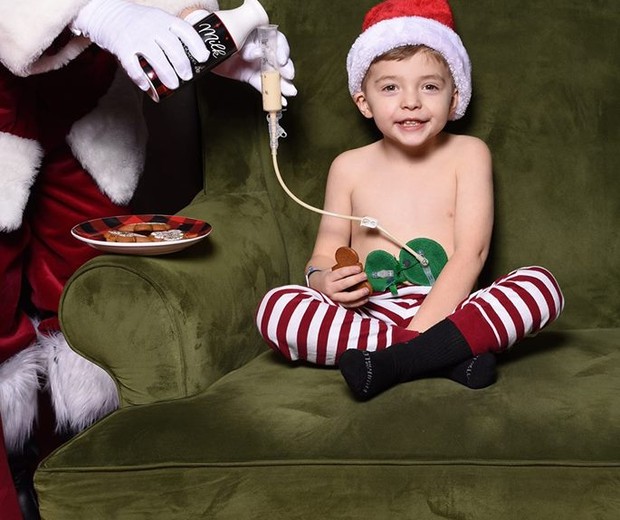 O pequeno Austin, 4, sorri simpático ao receber leite do Papai Noel (Foto: Reprodução Facebook)