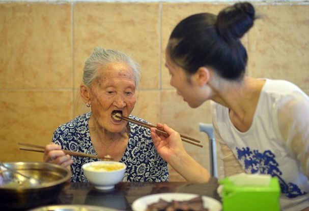 ...dá comida a senhorinha de 88 anos (Foto: Central European News)