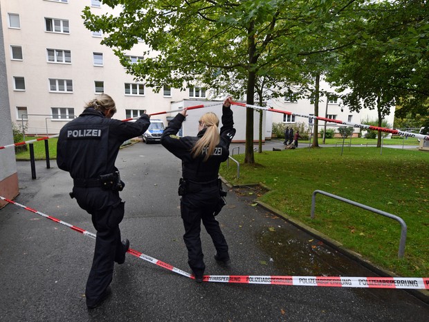 Policiais acessam região isolada em Chemnitz, no leste da Alemanha, neste domingo (9) onde uma operação busca um jovem sírio acusado de estar preparando um ataque a bomba  (Foto: Hendrik Schmidt/dpa via AP)
