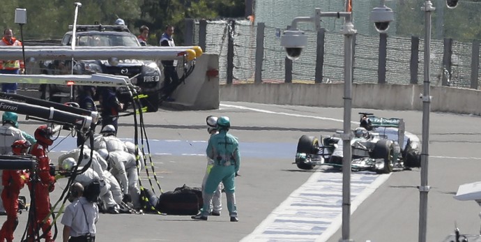 Lewis Hamilton chega ao boxes com pneu no aro após toque de Nico Rosberg, no GP da Bélgica (Foto: AP)