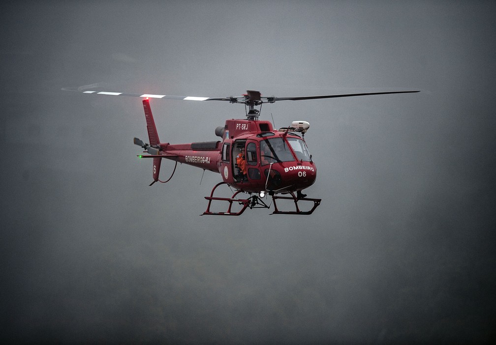 Um helicóptero dos bombeiros procura por sobreviventes após o deslizamento em Petrópolis (RJ) — Foto: Carl de Souza/AFP
