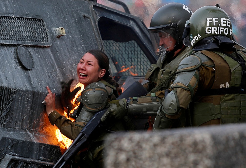 4 de novembro - Uma agente da polícia de choque é vista em chamas durante ação em um protesto contra o governo chileno em Santiago — Foto: Jorge Silva/Reuters