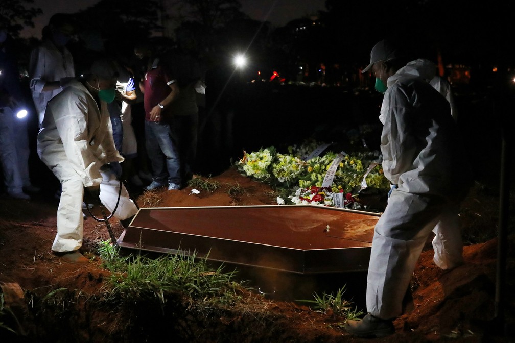 19 de junho - Coveiros com roupas de proteção enterram homem que morreu vítima de Covid-19, no cemitério de Vila Formosa — Foto: Amanda Perobelli/Reuters