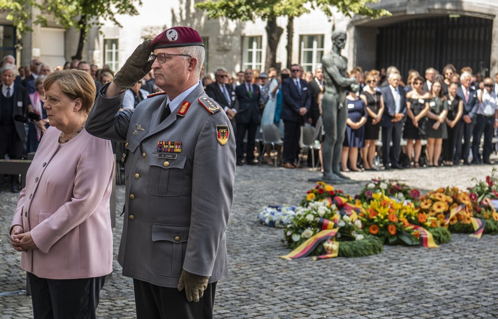 Angela Merkel e Eberhard Zorn , general das Forças Armadas, durante homenagem ao homem que organizou uma conspiração contra Hitler — Foto: John MacDougall/AFP