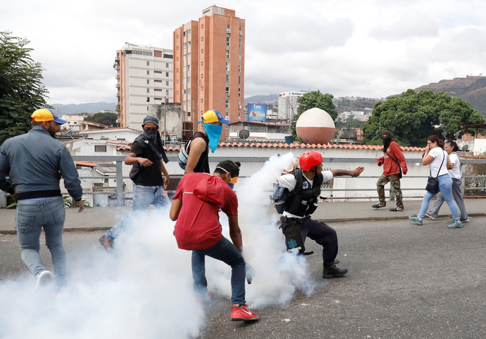 Manifestantes contrários ao governo de Nicolás Maduro reagem ao lançamento de bomba de gás lacrimogêneo em Caracas, em imagem de arquivo — Foto: Manaure Quintero/ Reuters