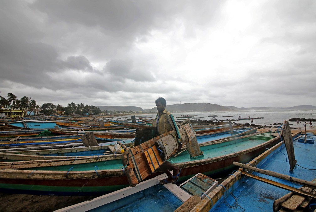 Um pescador carrega ferramentas enquanto deixa um local em busca de abrigo Ã  medida que o ciclone Fani se aproxima de Visakhapatnam, na Ãndia, nesta quarta (1Âº). â€” Foto: Stringer/Reuters