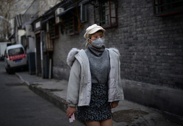 Mulher caminha por rua de Pequim com máscara em meio a surto de coronavírus (Foto: REUTERS/Tingshu Wang)