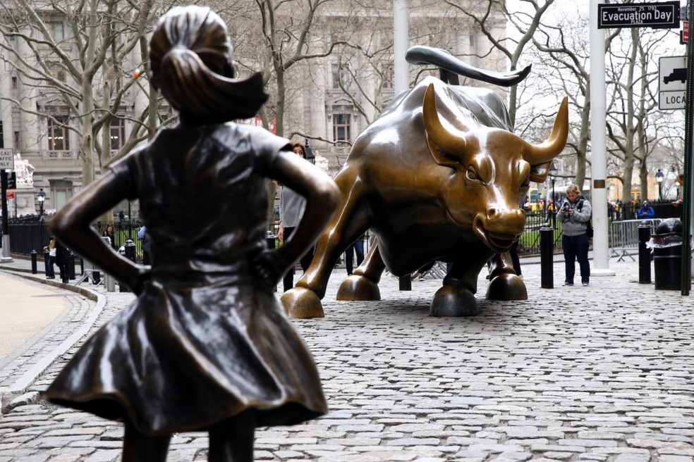 A estátua da "Garota Destemida" (Fearless Girl) em Nova York é considerada um símbolo do fortalecimento feminino no mercado financeiro (o touro é um dos símbolos de Wall Street) — Foto: GettyImages