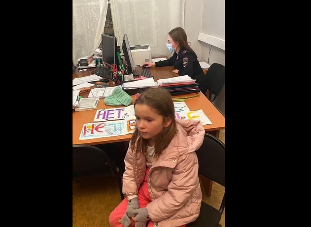 Menina aparece sentada em uma delegacia após protesto (Foto: Reprodução/Daily Mail)