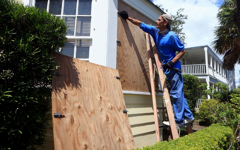 David Montes cobre as janelas de casa com placas de madeira em preparação para a chegada do furacão Harvey, em Corpus Christi, Texas, na quinta (24 (Foto: Gabe Hernandez/Corpus Christi Caller-Times via AP)