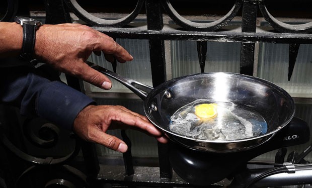 Homem chegou a fritar um ovo nesta quarta-feira (4) usando o reflexo do sol do polêmico arranha-céu de Londres  (Foto: Suzanne Plunkett/Reuters)