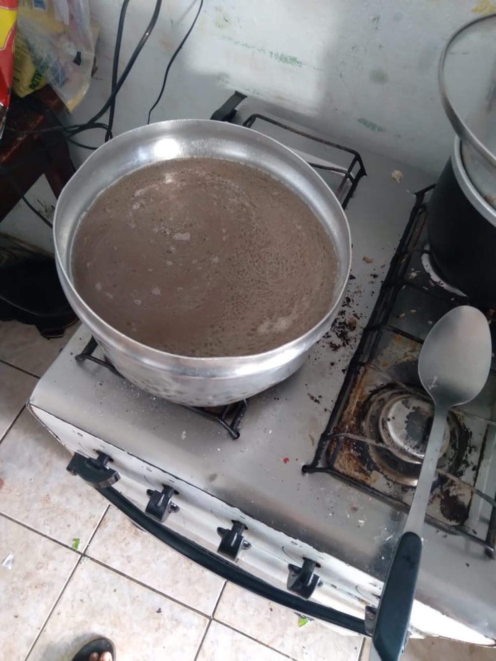 Panela utilizada pela família para preparar feijão em fogão velho e enferrujado — Foto: Divulgação
