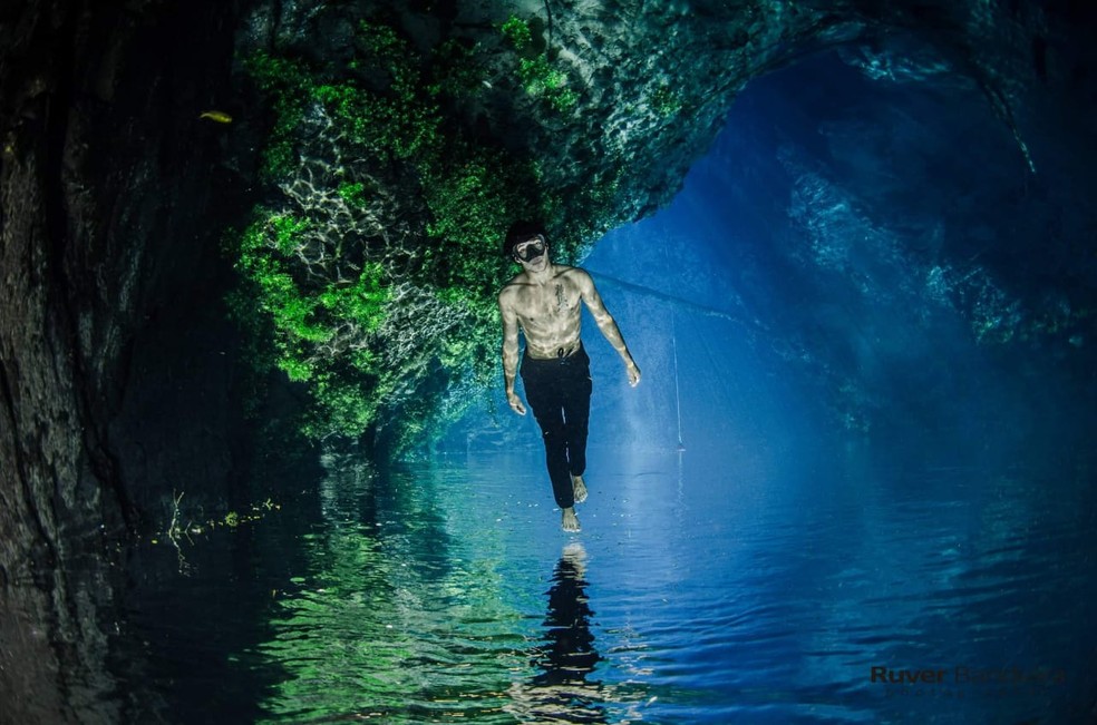 Modelo fotográfico em caverna inundada 'anda' sobre as águas durante ensaio. — Foto: Ruver Bandeira/Foto