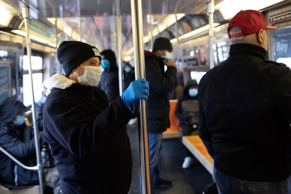 Vários passageiros usam máscaras na tentativa de evitar a contaminação pelo novo coronavírus no metrô, no distrito do Brooklyn, em Nova York, na quarta-feira (25) — Foto: David Boe/AP 