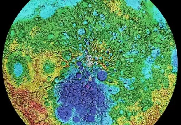 As cores mostram altitudes no Pólo Sul da Lua: roxo (profundidade superior a 9 mil metros), verde (altitude zero), amarelo (2 mil metros acima do nível da superfície), laranja (4 mil metros) e vermelho (8,2 mil metros). A Bacia de Aitken, uma cratera com  (Foto: SCIENCE PHOTO LIBRARY (via BBC))