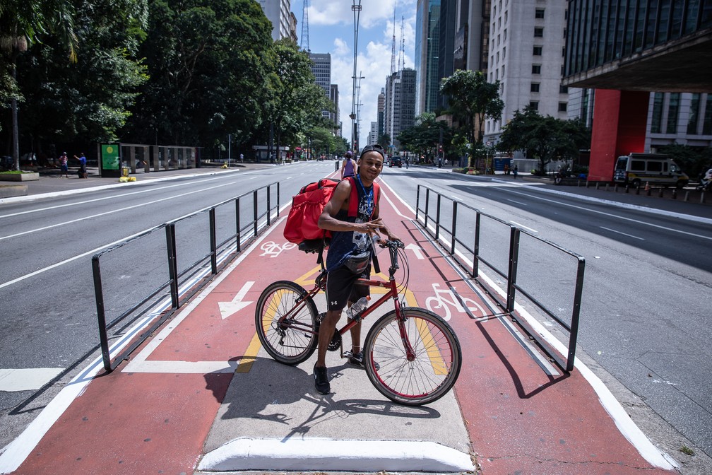 Leandro Tavares, entregador de comida por aplicativos de 21 anos, espera pedidos na Avenida Paulista — Foto: Fábio Tito/G1