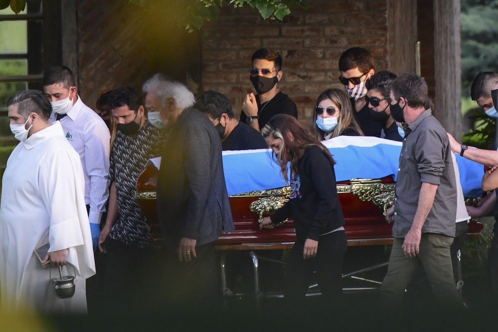 Família acompanha caixão com o corpo de Maradona, em cemitério de Bella Vista, nesta quinta-feira (26).  — Foto: RONALDO SCHEMIDT / AFP
