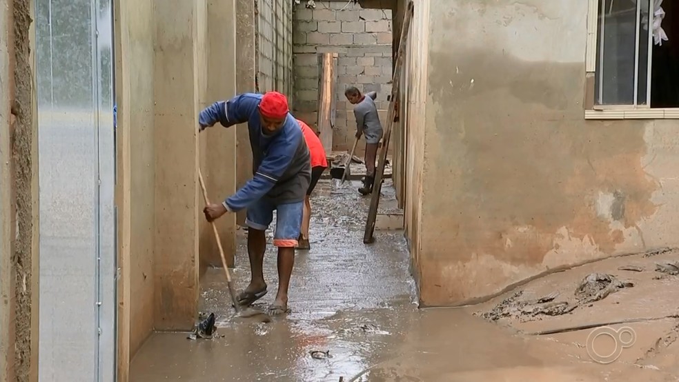 Moradores limpam sujeira e lama após Rio Tietê baixar em Araçariguama — Foto: TV TEM/Reprodução