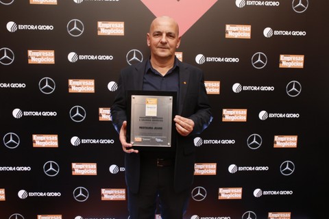Flavio Conrad, da Restaura Jeans, posa com seu troféu durante o evento