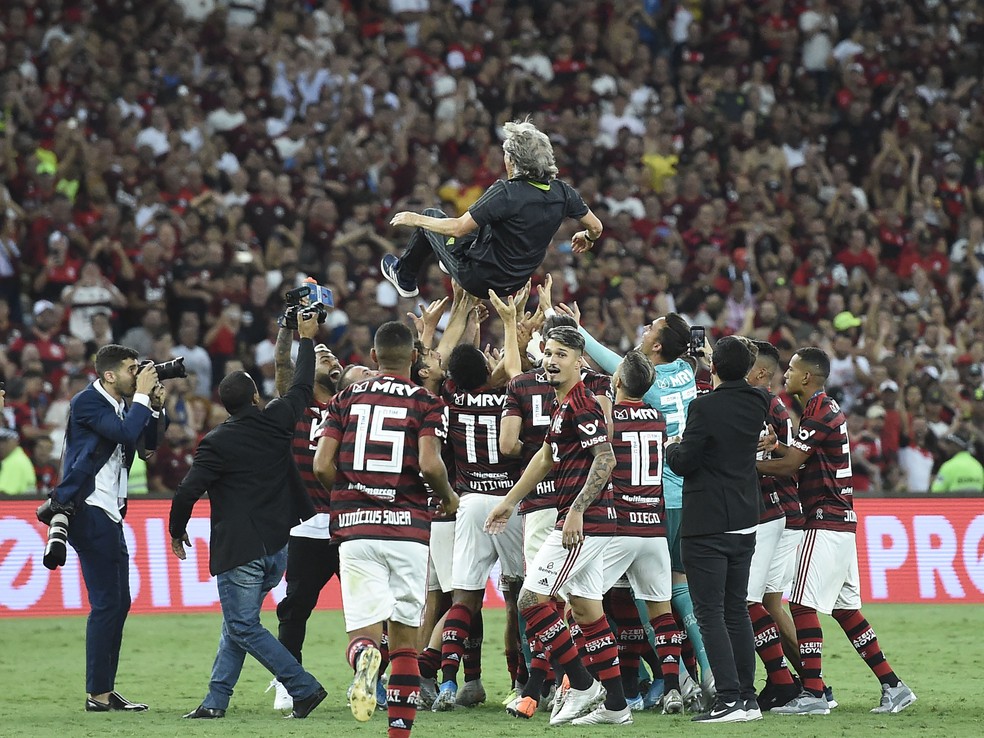 Jorge Jesus é jogado para o alto pelos jogadores do Flamengo em festa pelo título do Brasileirão — Foto: André Durão