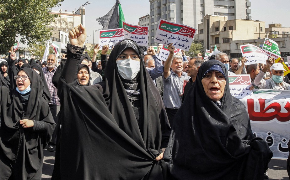 Mulheres e homens cantam slogans enquanto marcham em uma manifestação pró-hijab na capital do Irã, Teerã, em 23 de setembro de 2022