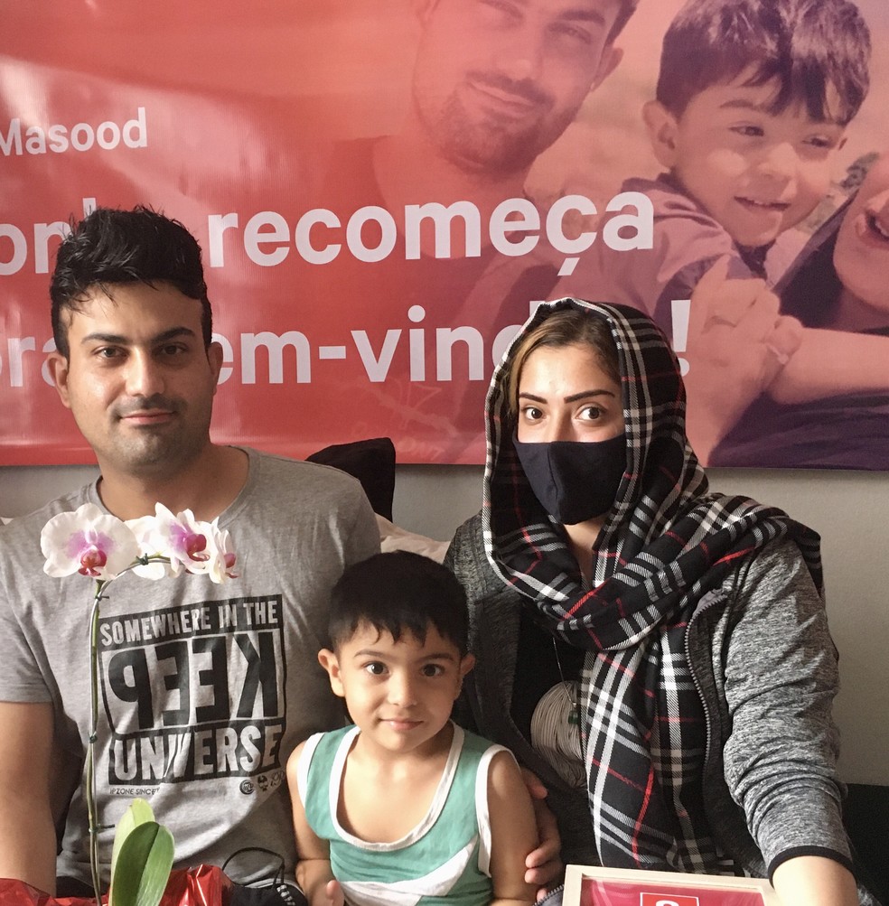 Masood, Sobhan e Lina Habibi em São Paulo; ao fundo, faixa de boas-vindas — Foto: Paula Lago/g1