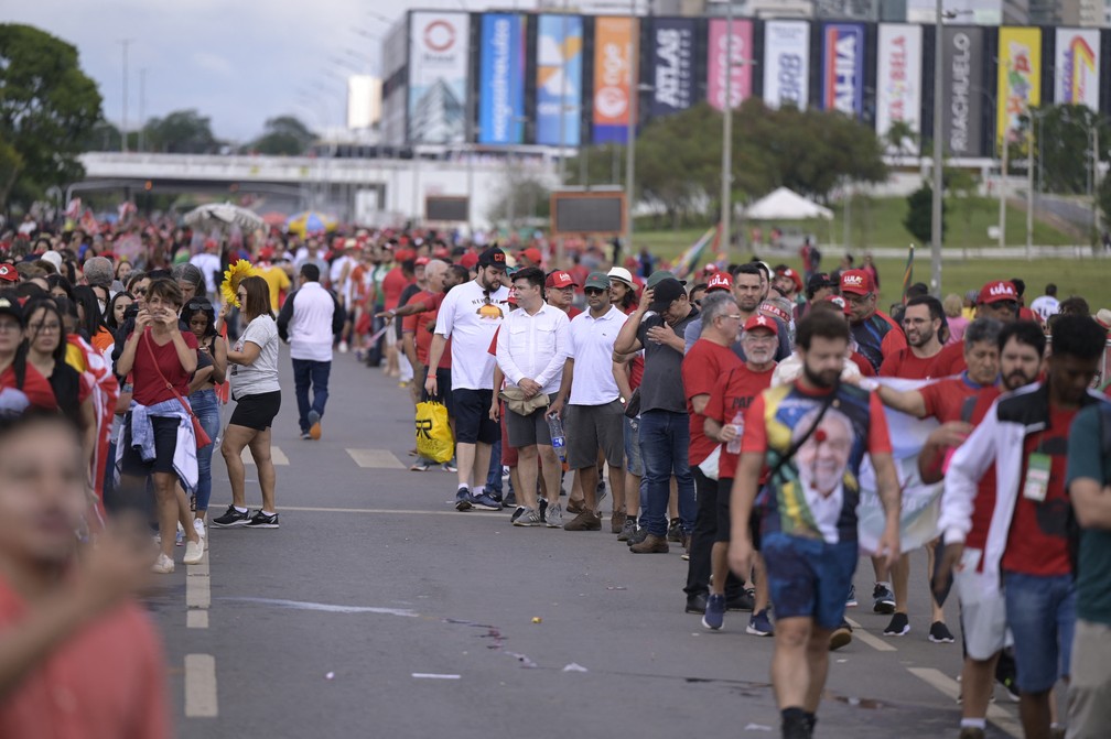 Apoiadores do presidente eleito Lula fazem fila para entrar em área da Esplanada dos Ministérios, em Brasília, neste domingo (1º) — Foto: Douglas Magno/AFP