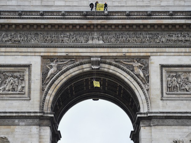 Ativistas do Greenpeace exibem uma faixa com os dizeres 'Senhor Hollande (presidente francês), renove a energia' no Arco do Triunfo em Paris, na França (Foto: Martin Bureau/AFP)