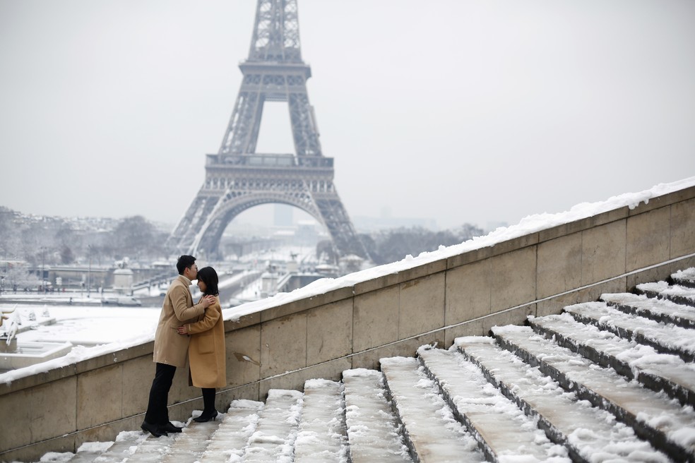 Casal  com Torre Eiffel fechada ao fundo (Foto: Michel Euler/AP)