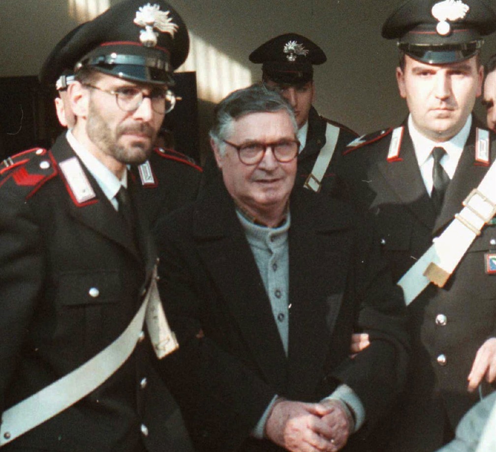 Foto de 16 de janeiro de 1996 mostra o 'chefe dos chefes' da máfia siciliana, Toto Riina, sendo escoltado até o tribunal em Bolonha, na Itália.  (Foto: Gianni Schicchi/ AP)