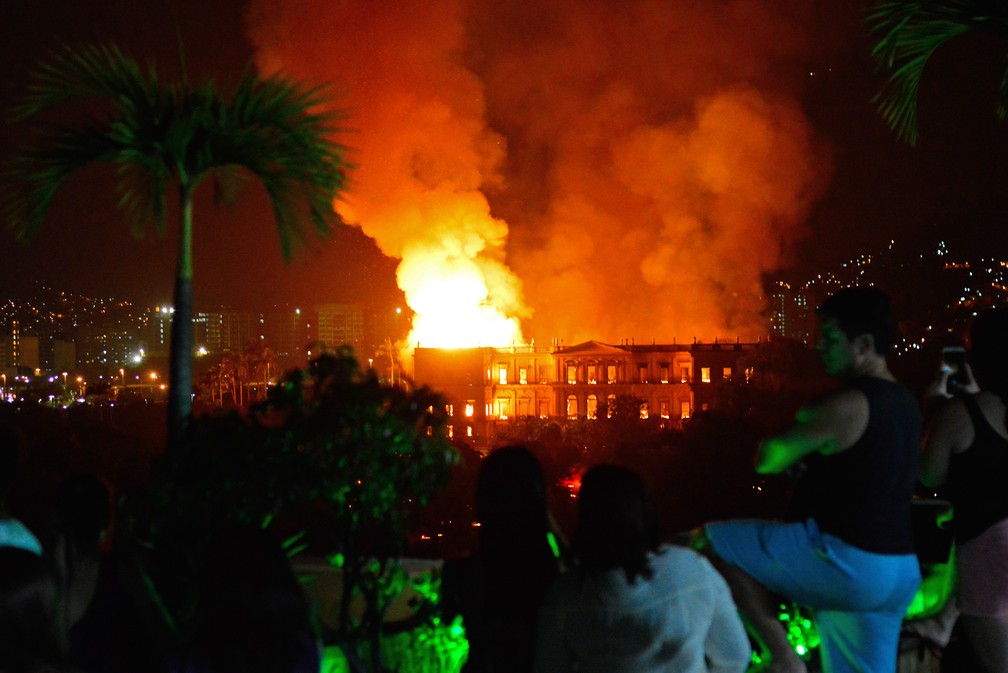 2 de setembro â Pessoas observam o Museu Nacional, no Rio de Janeiro, ser consumido por um incÃªndio de grandes proporÃ§Ãµes. O fogo destruiu o acervo com mais de 20 milhÃµes de itens â Foto: AFP