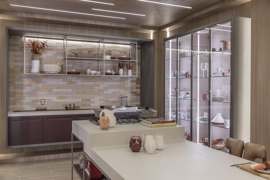 Uma cozinha moderna e 100% integrada pede uma iluminação que mantenha esse conceito. Nesse projeto de Barbara Jalles, as luminárias lineares foram embutidas nas ripas da marcenaria