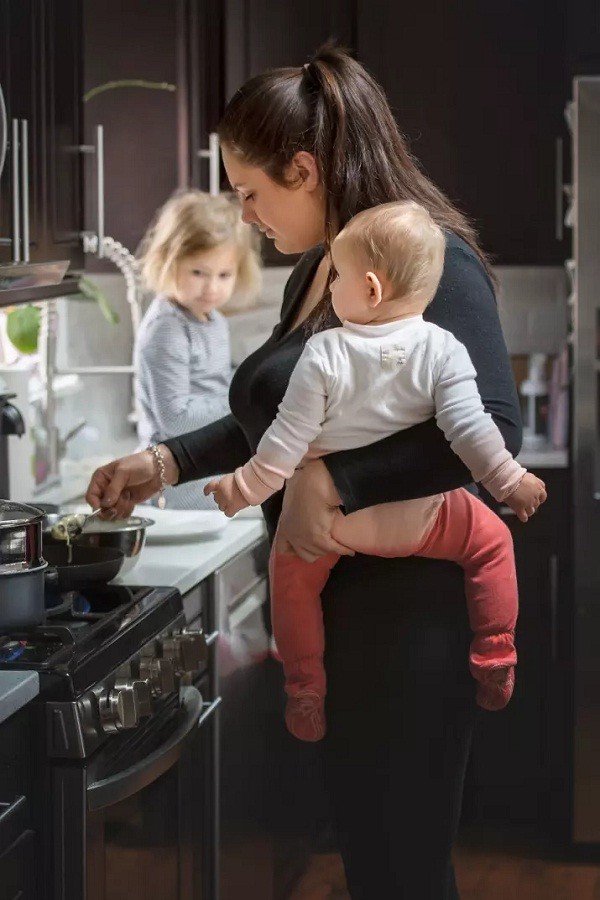 Mãe cozinha com uma única mão enquanto carrega bebê (Foto: Reprodução/Pictures By GG)