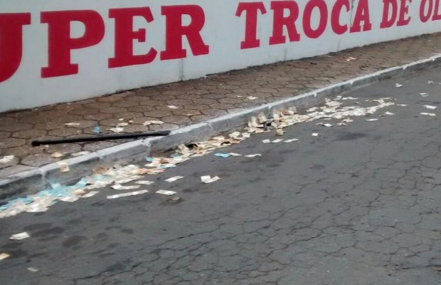 Dinheiro furtado ficou espalhado pela rua durante tentativa de fuga, em Goiânia, Goiás (Foto: Divulgação/PM)
