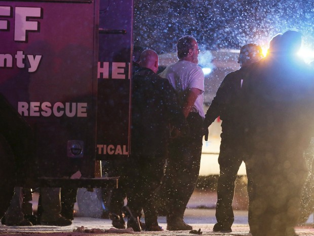 Suspeito é escoltado por policiais na saída do prédio Planned Parenthood de Colorado Springs, após um tiroteio que durou cerca de cinco horas na sexta (27) (Foto: Reuters/Isaiah J. Downing)