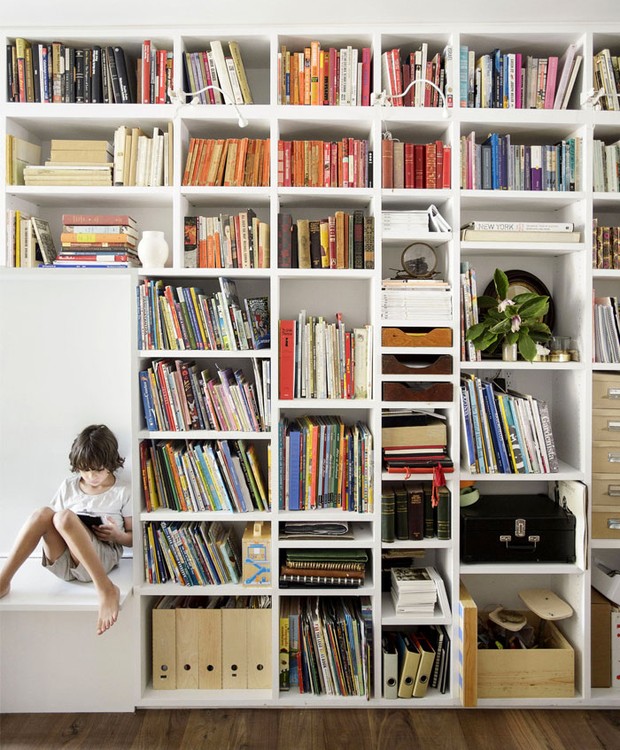 A estante funciona como uma biblioteca e os livros colorem a decoração (Foto: Indecora/ Reprodução)