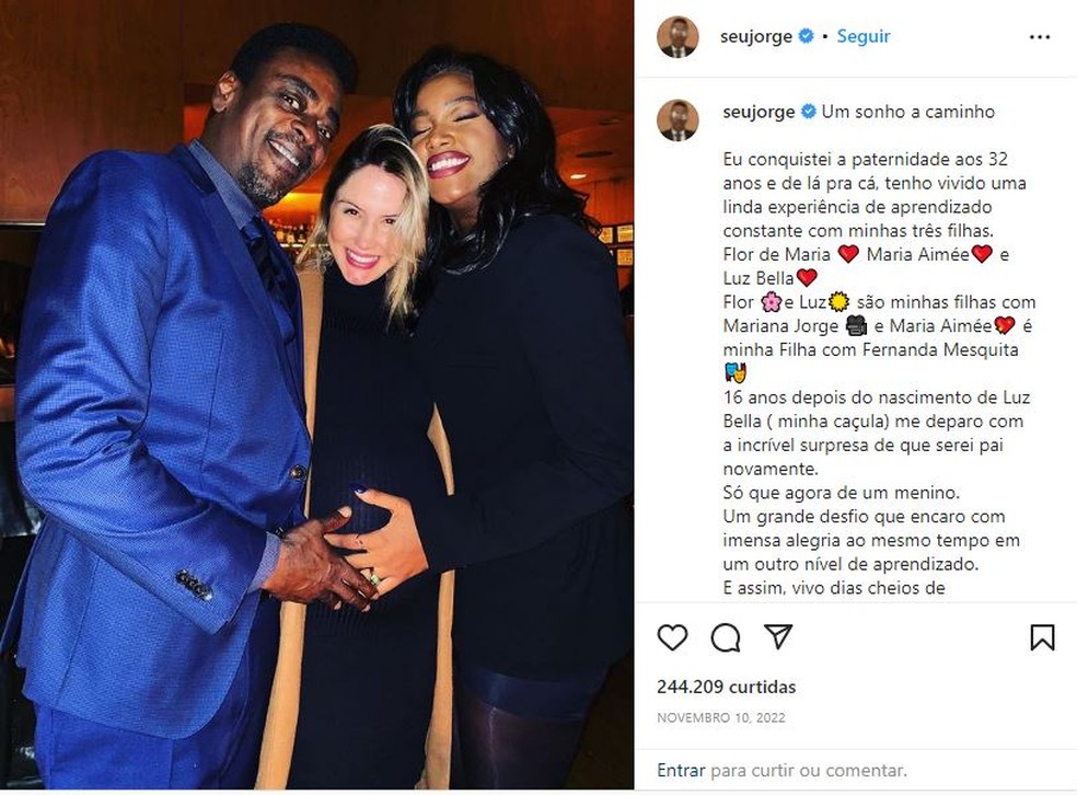 Seu Jorge publicou foto no ano passado na sua rede social com a mão na barriga da companheira, Karina Barbieri, para comemorar o nascimento do filho. Ao lado do casal, a cantora Iza — Foto: Reprodução/Instagram