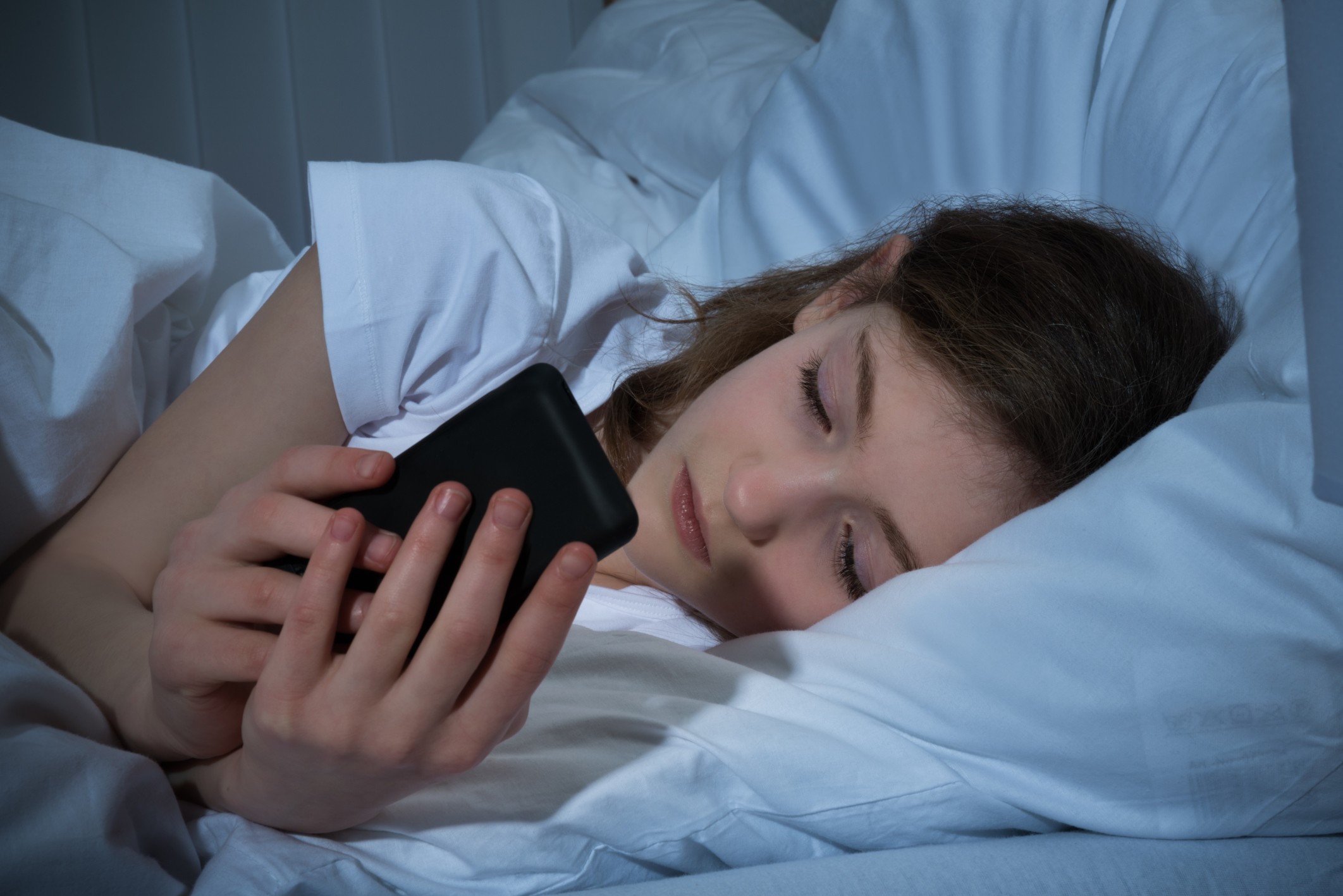 Menina mexendo no celular na cama (Foto: Thinkstock)