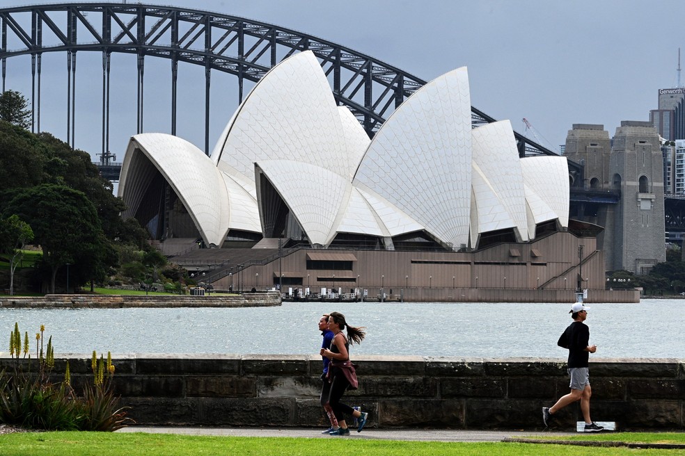Australianos correm ao longo do porto de Sydney após autoridades relaxarem algumas restrições impostas devido à pandemia de Covid-19 no estado de Nova Gales do Sul — Foto: Saeed Khan/AFP